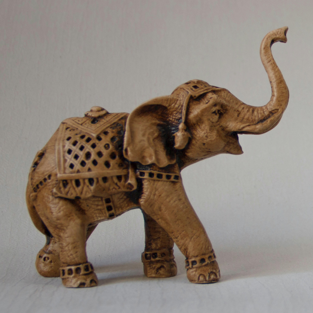 Carved elephant figurine with raised trunk — Asian symbol of fortune and strength