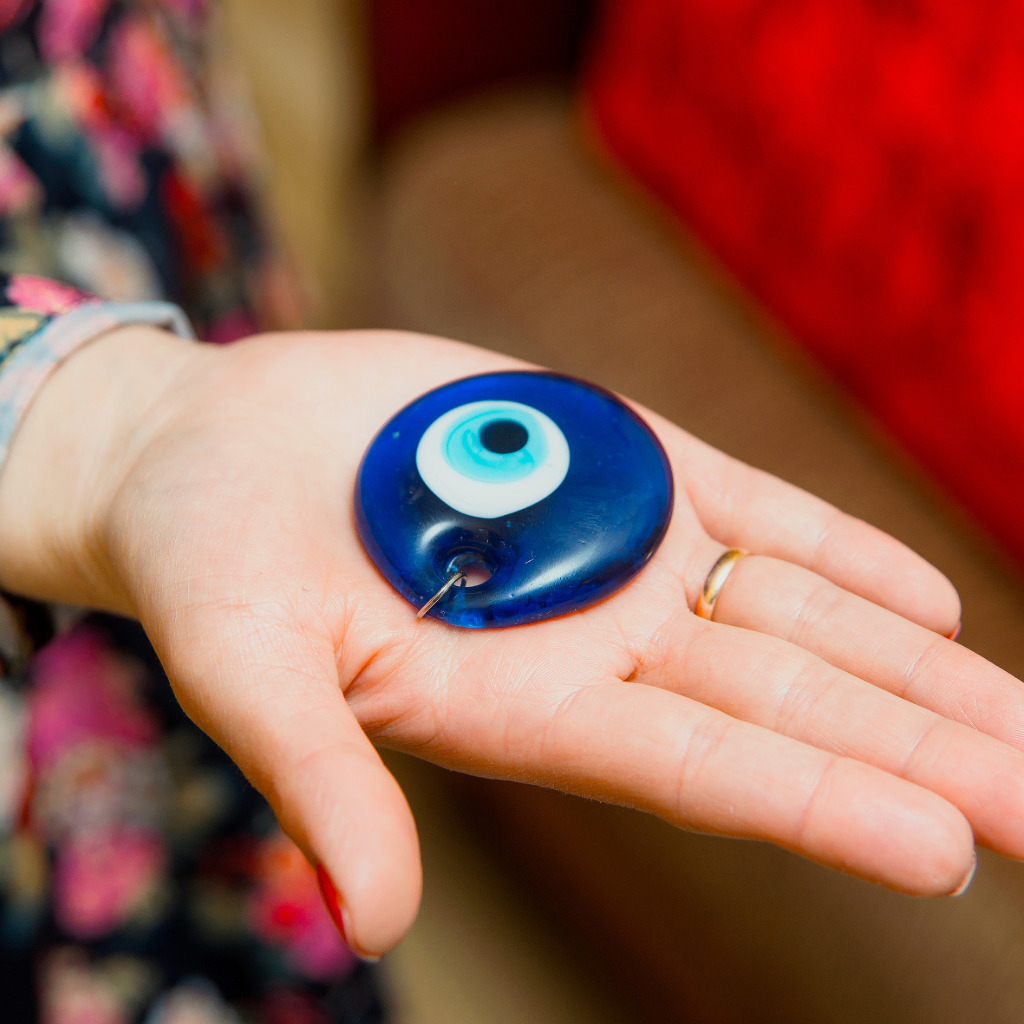 Blue glass Turkish nazar boncuk evil-eye bead held in an open hand