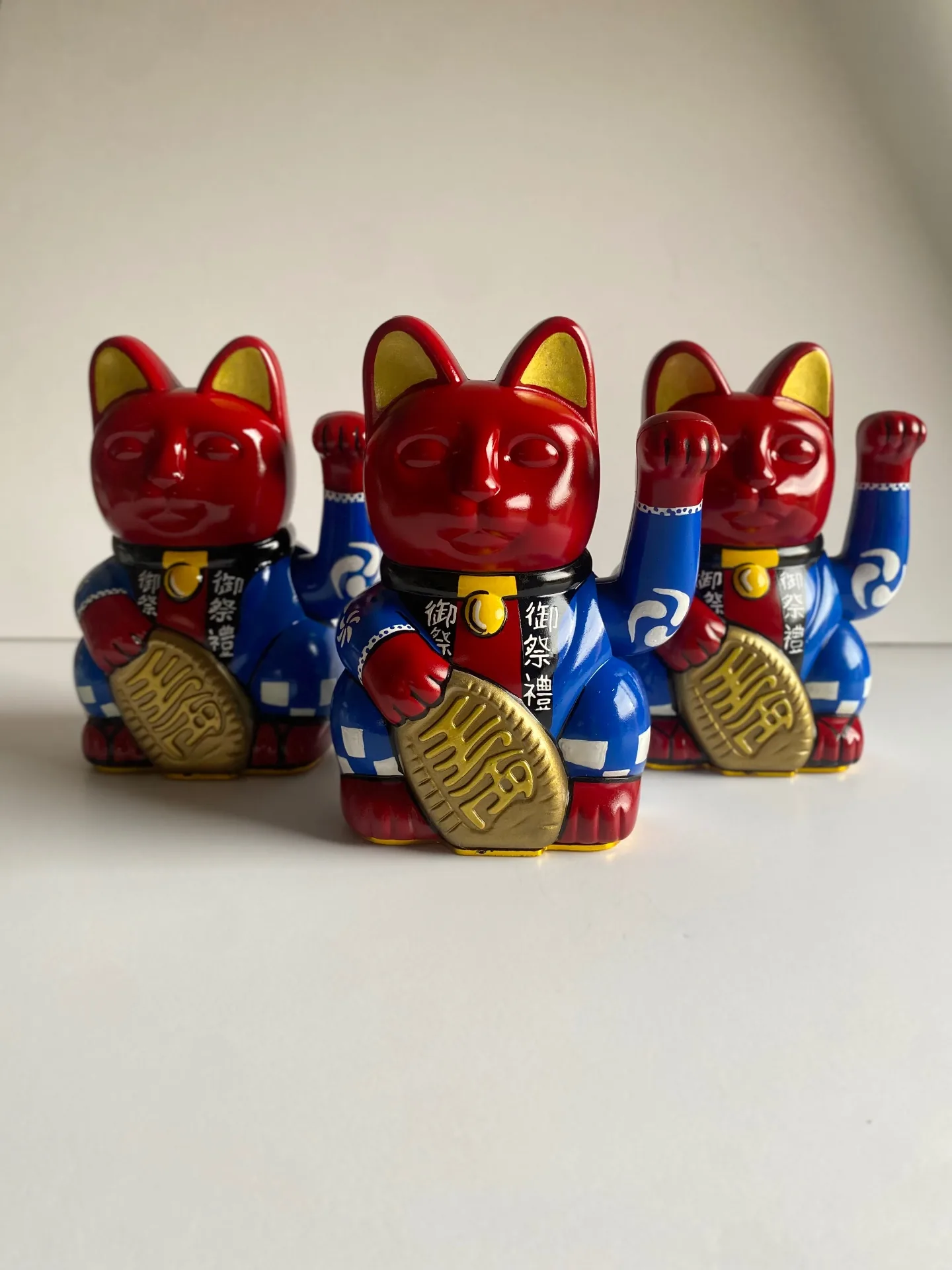 Trio of red and blue hand-painted Maneki Neko Lucky Cats in a Japanese-inspired display