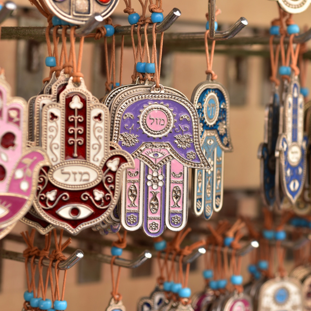 Collection of Hamsa hand amulets in pink, purple and blue — protective Hand of Fatima symbols
